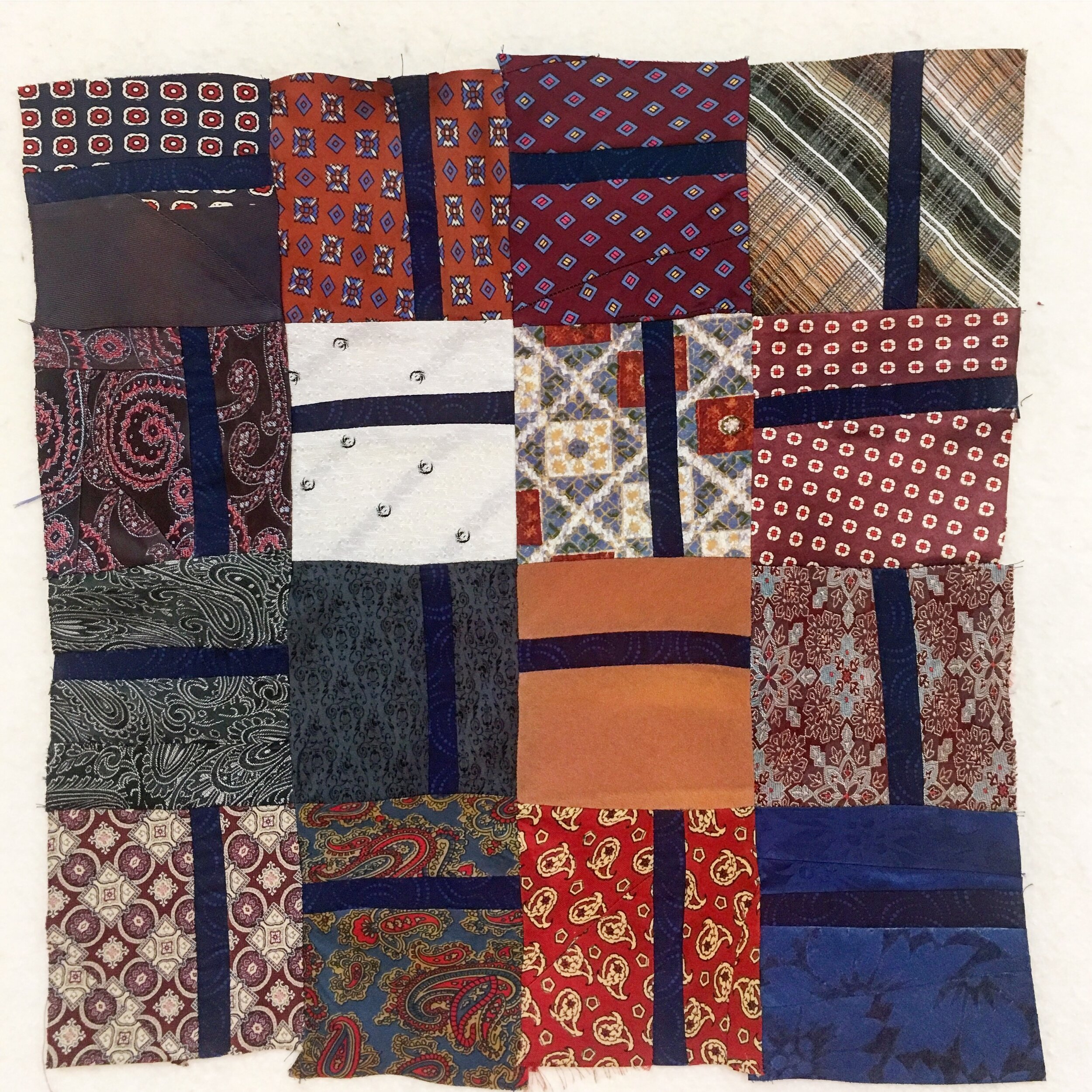 the rough placement of the silk labels of ties to create a quilted pillow