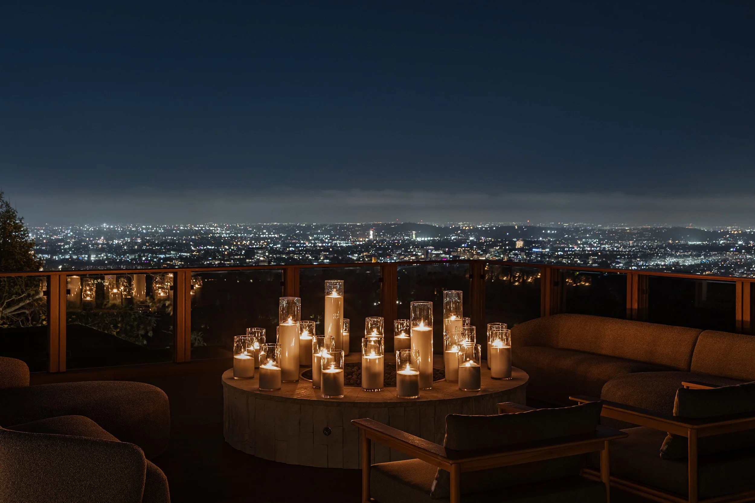 Franklin Canyon Beverly Hills luxury home rooftop terrace at night with modern firepit, candles & city light views