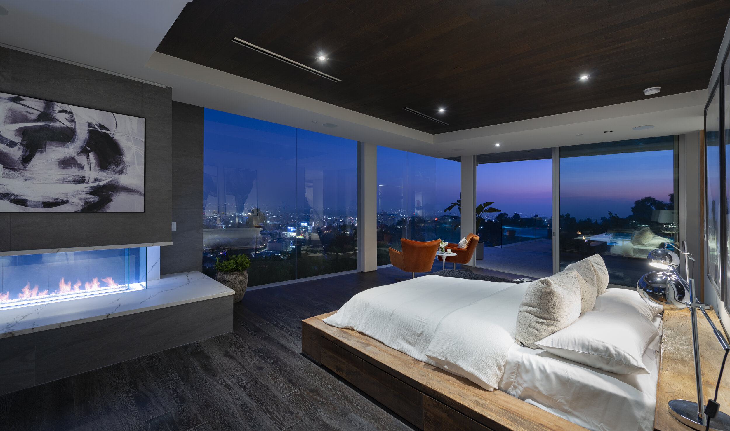 Ultra modern bedroom with floor to ceiling glass walls and bedside fireplace