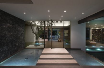 Benedict Canyon modern luxury Beverly Hills home front entrance walkway that crosses pools of water and meets a living indoor tree