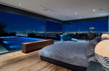 Luxury modern bedroom with floor to ceiling glass walls and views from bed at our Hopen Place house in the Hollywood Hills