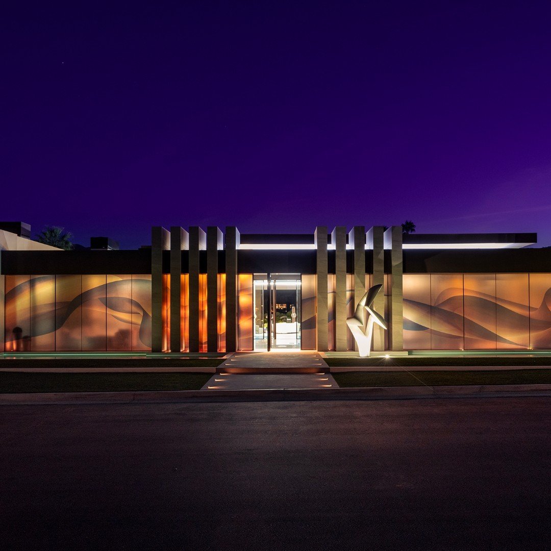 Serenity's modern fa&ccedil;ade features vertical columns, a @richard_erdman marble sculpture, and a translucent mural that captures the motion and colors of the desert hills. Photo by @maccollum