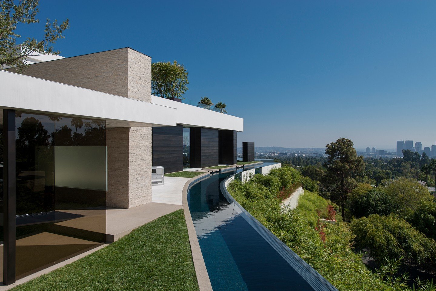 The wraparound moat pool at Laurel Way offers a luxury swimming experience, while adding a protective boundary to the house, without obstructing the views. Photos by @maccollum and Art Gray Photography.