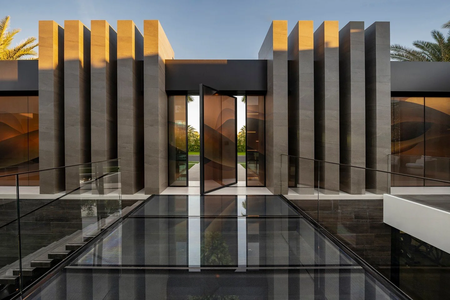 The modern entrance to our Serenity house in Indian Wells, featuring a floating glass walkway and minimalist lines. Photo by @maccollum