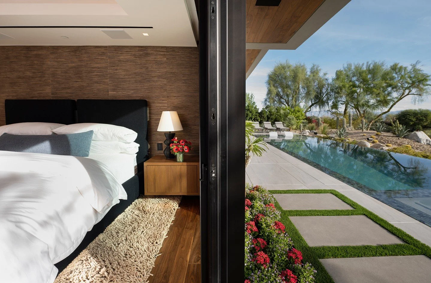 The resort style primary bedroom at our Bighorn house opens directly onto the pool terrace, for seamless indoor outdoor living and views. Photo by @maccollum