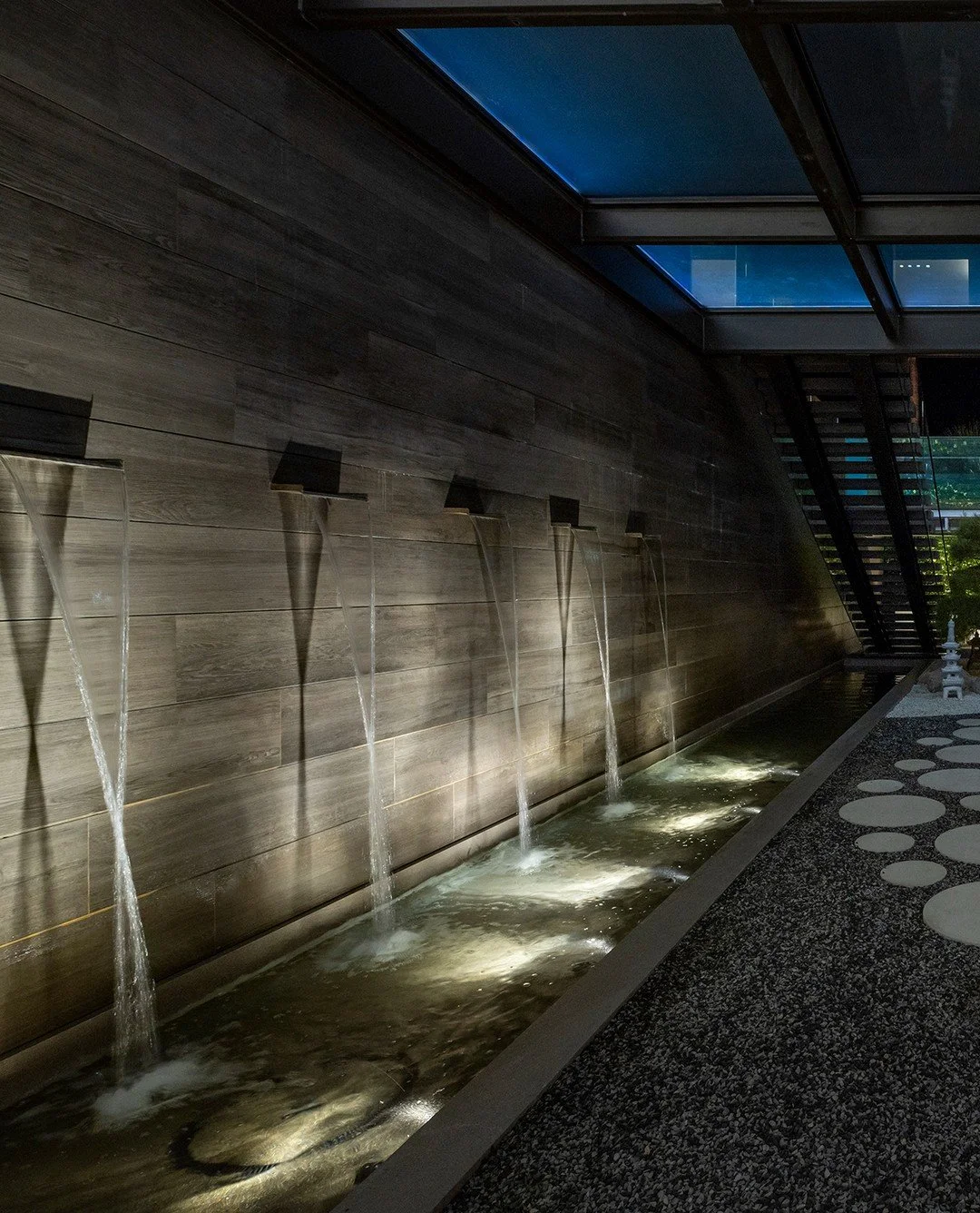 The modern courtyard garden with fountains and stone details, adjacent to the indoor outdoor luxury home theater at our Serenity house in Indian Wells. Photo by @maccollum