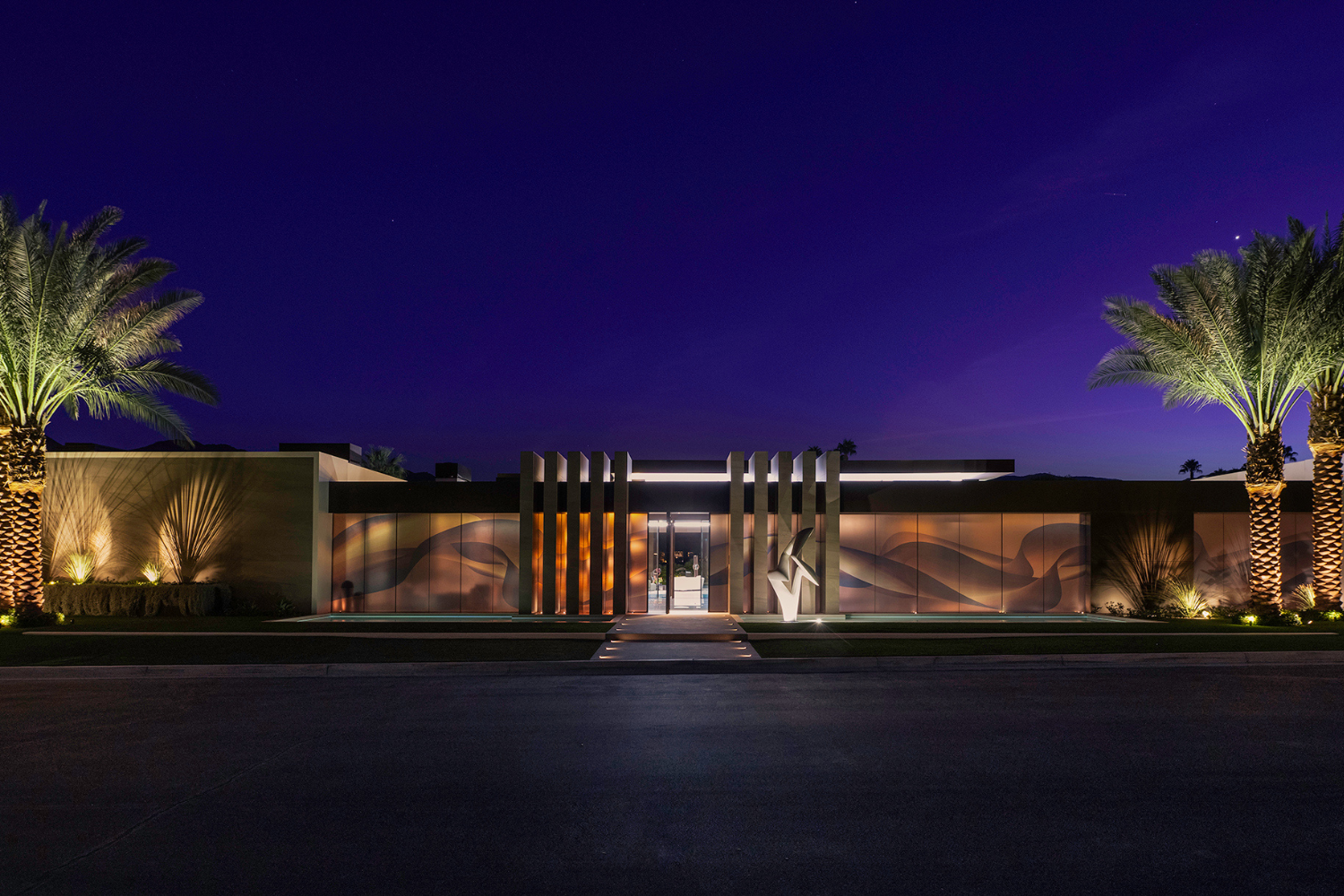 Serenity luxury desert mansion with modern architectural design, palm trees & purple nighttime sky