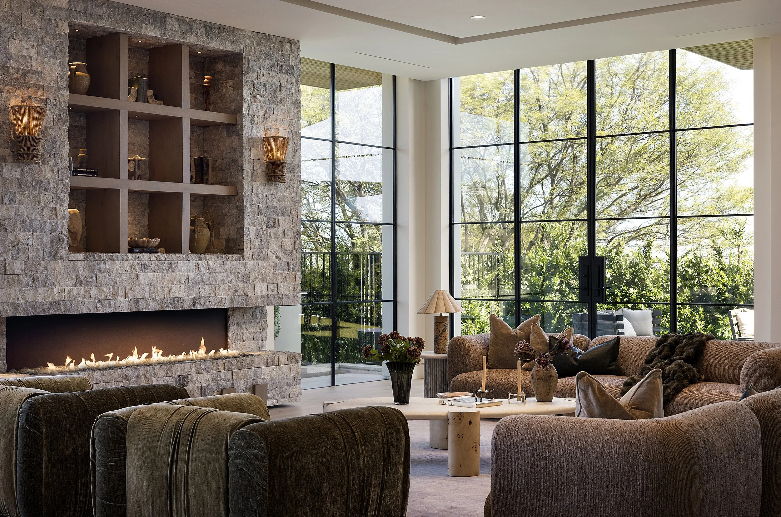 Laurel House Beverly Hills luxury home modern living room with textured stone fireplace & light filled window wall