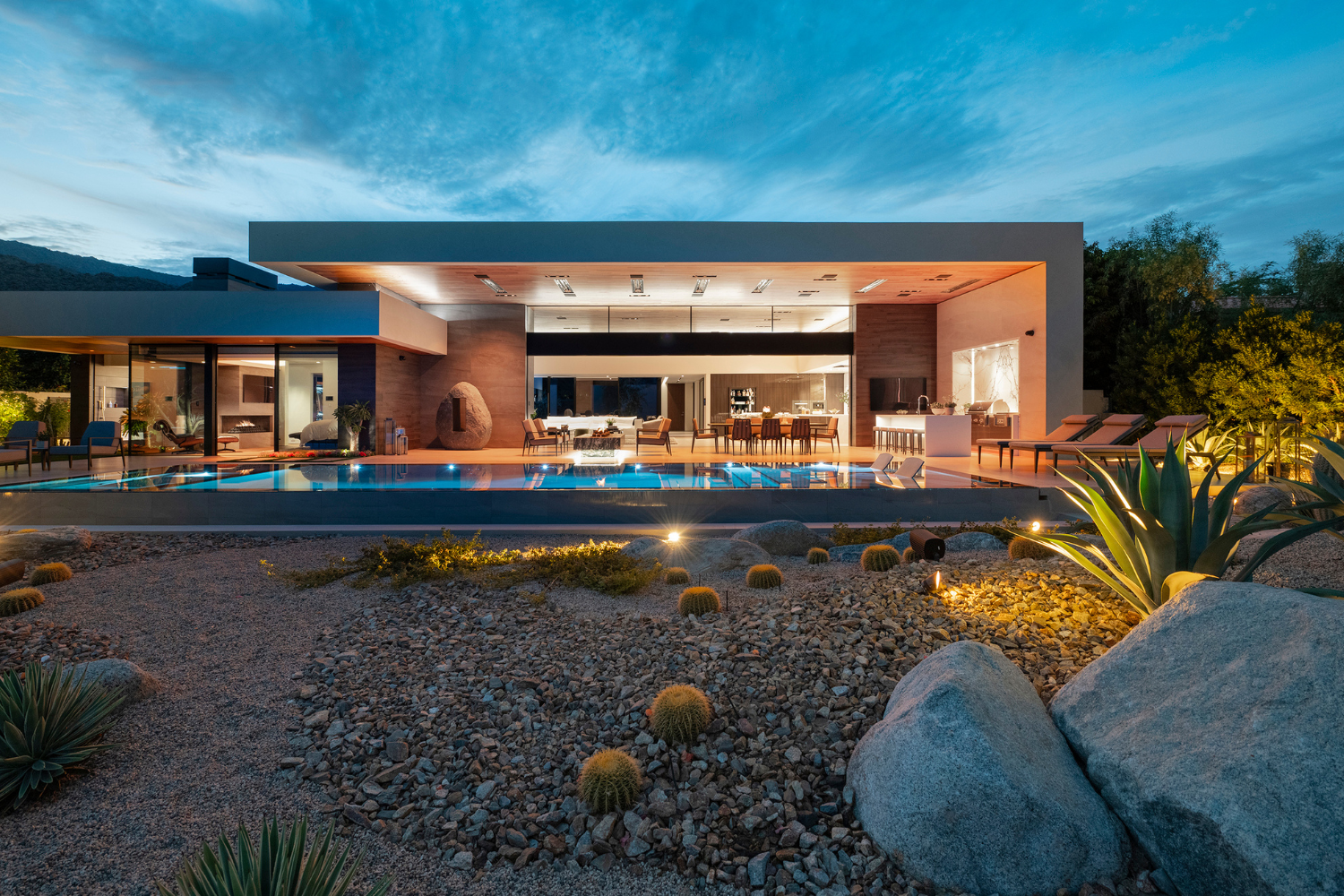 Bighorn luxury resort style modern desert home wit sliding glass walls open to a backyard pool terrace with desert garden landscaping