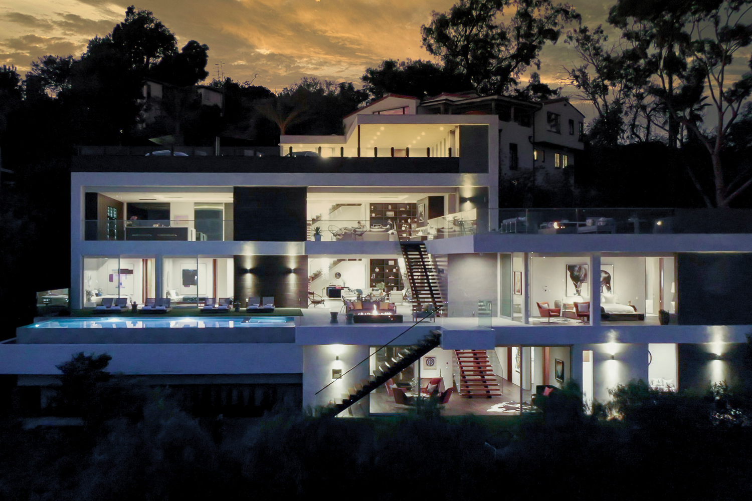 Los Tilos luxury modern indoor outdoor mansion in the Hollywood Hills, Los Angeles, seen lit up at dusk