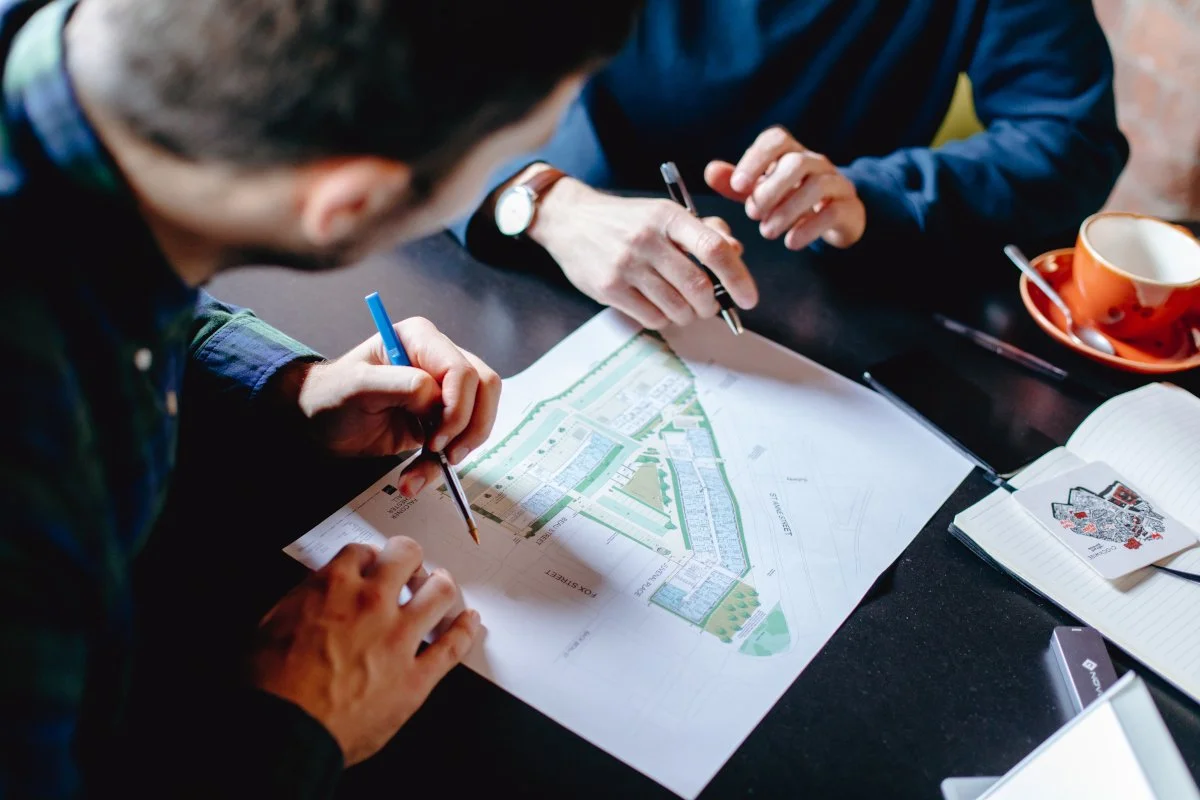 two men in shirts reviewing a site plan