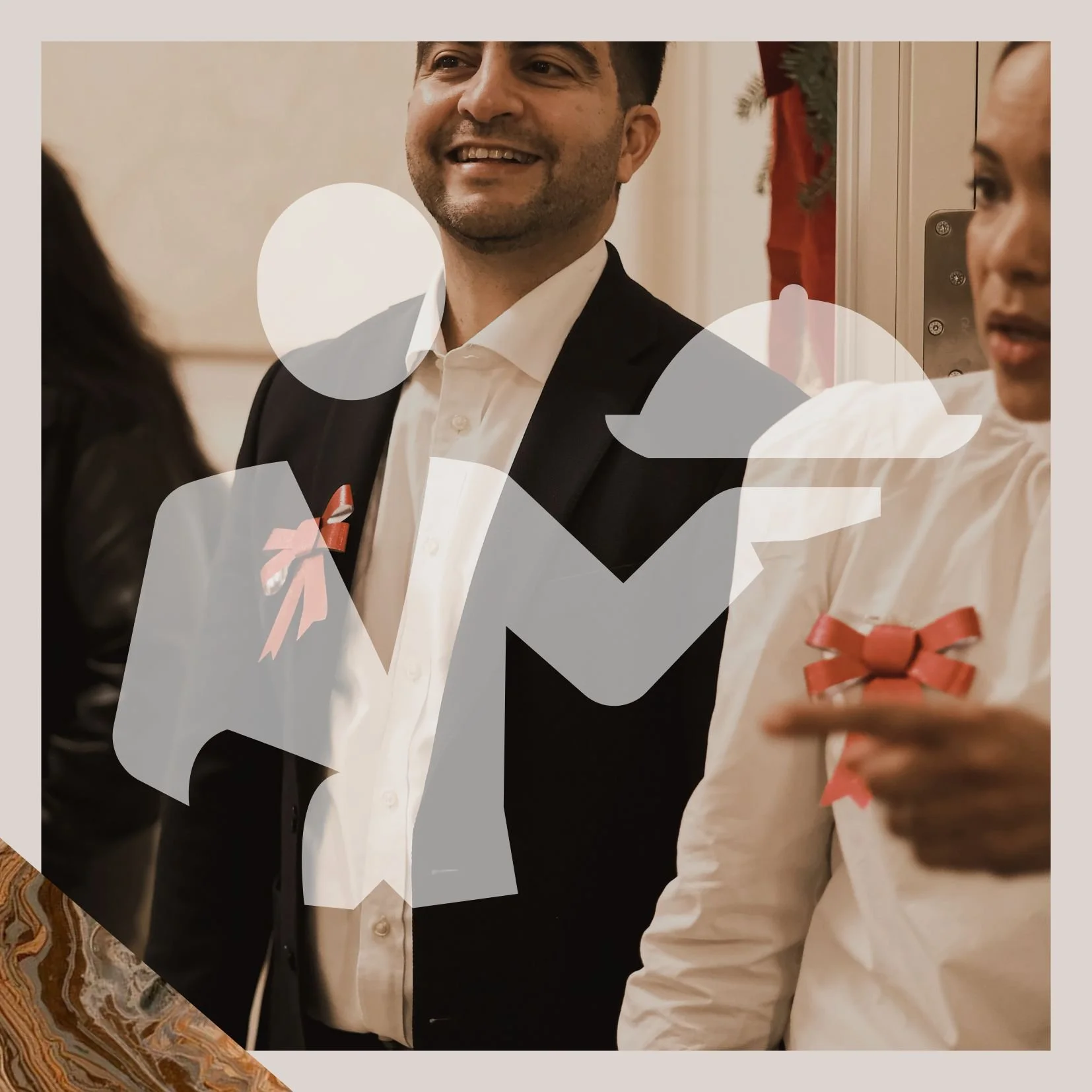 Groupe de personnes en conversation lors d'une célébration, portant des rubans rouges, dans une ambiance festive.