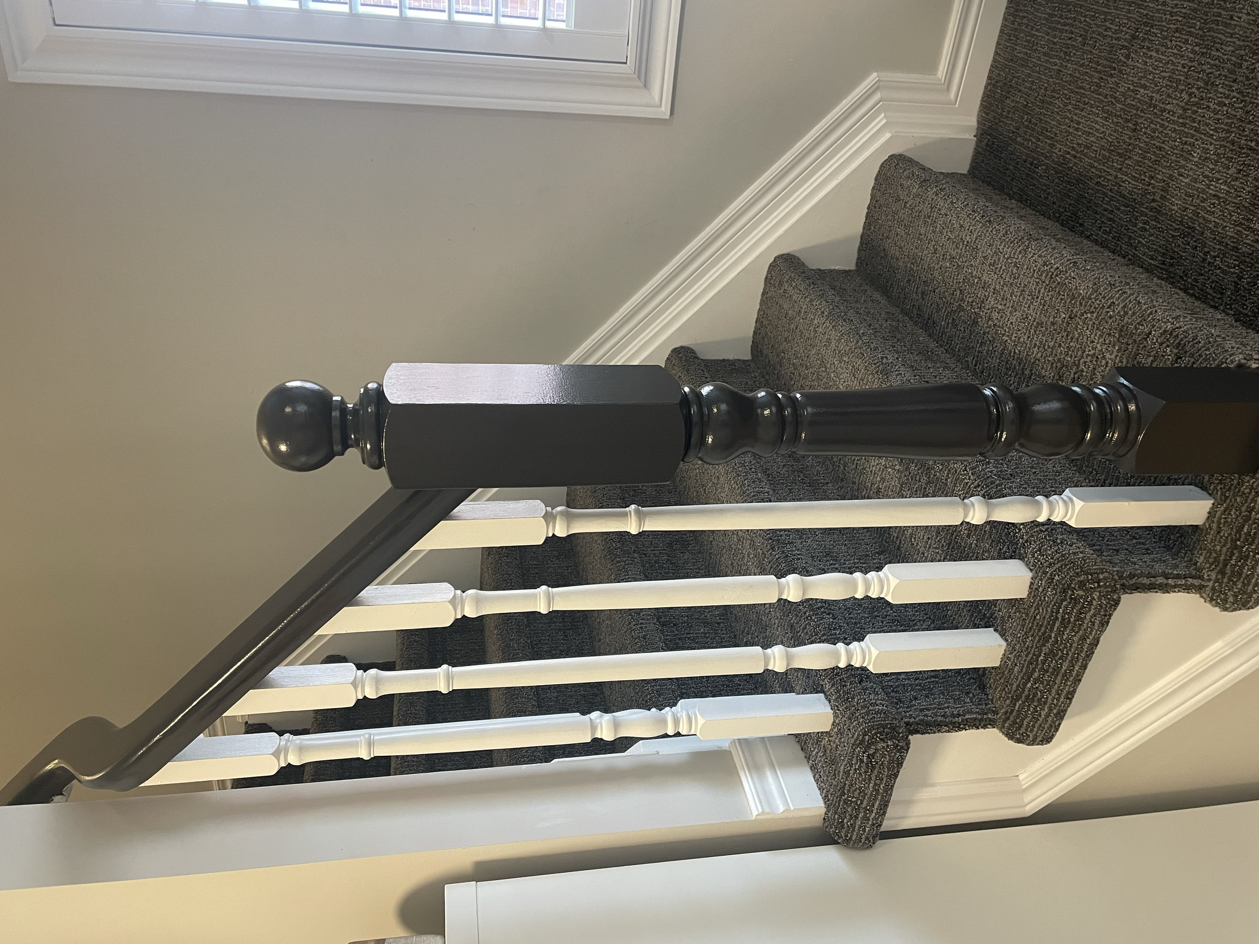View of a staircase with dark wooden and white painted handrails, carpeted steps, beige wall, white window frame, and trim.
Interior House Painting. Heather Feather Painting and Design. Toronto. Stair Refinishing.