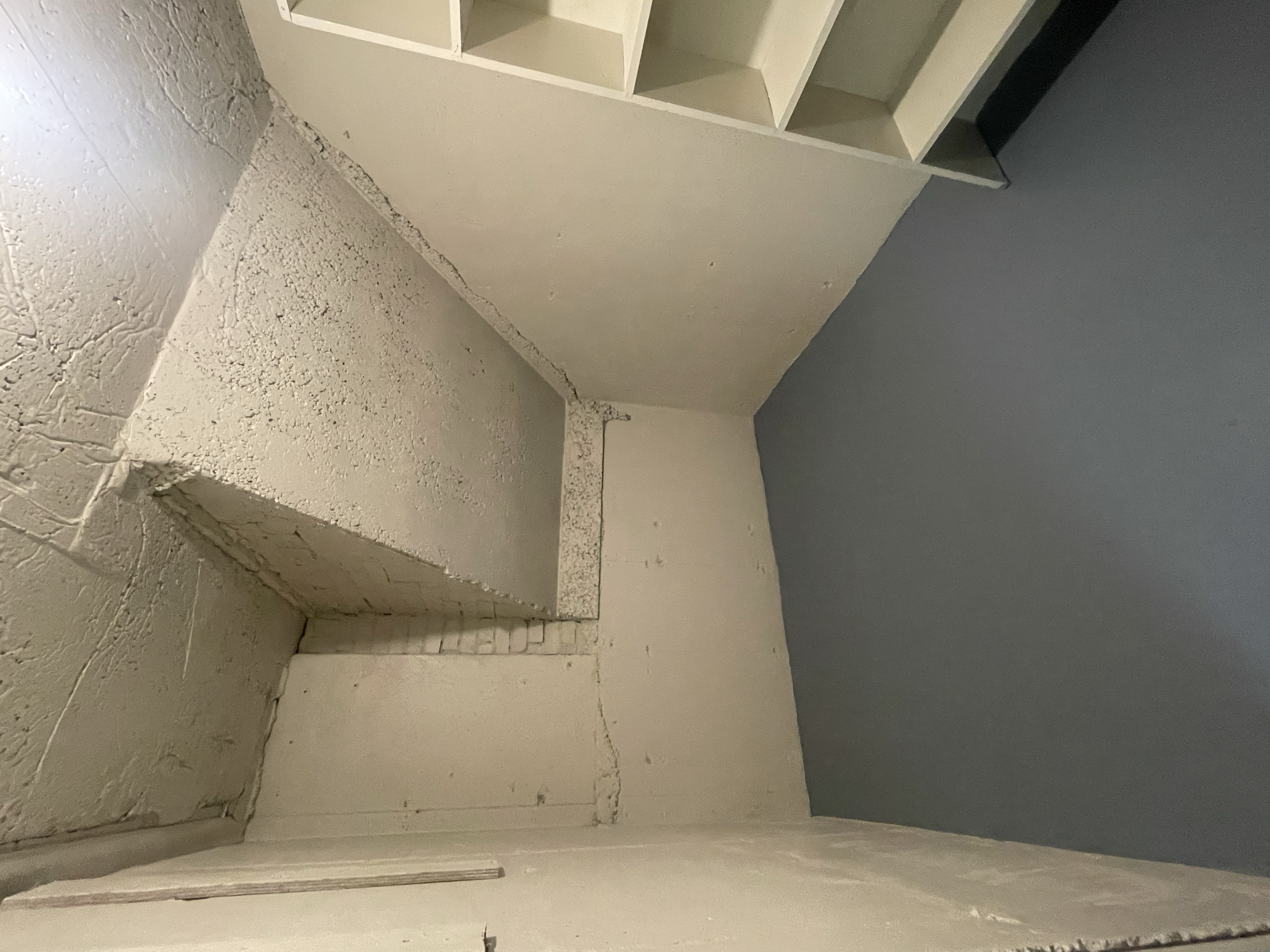 A corner of a room showing unfinished wall and ceiling with visible drywall and brickwork, and a section of a dark gray wall.
Interior House Painting. Heather Feather Painting and Design. Toronto. Cold Cellar Painting. Spraying