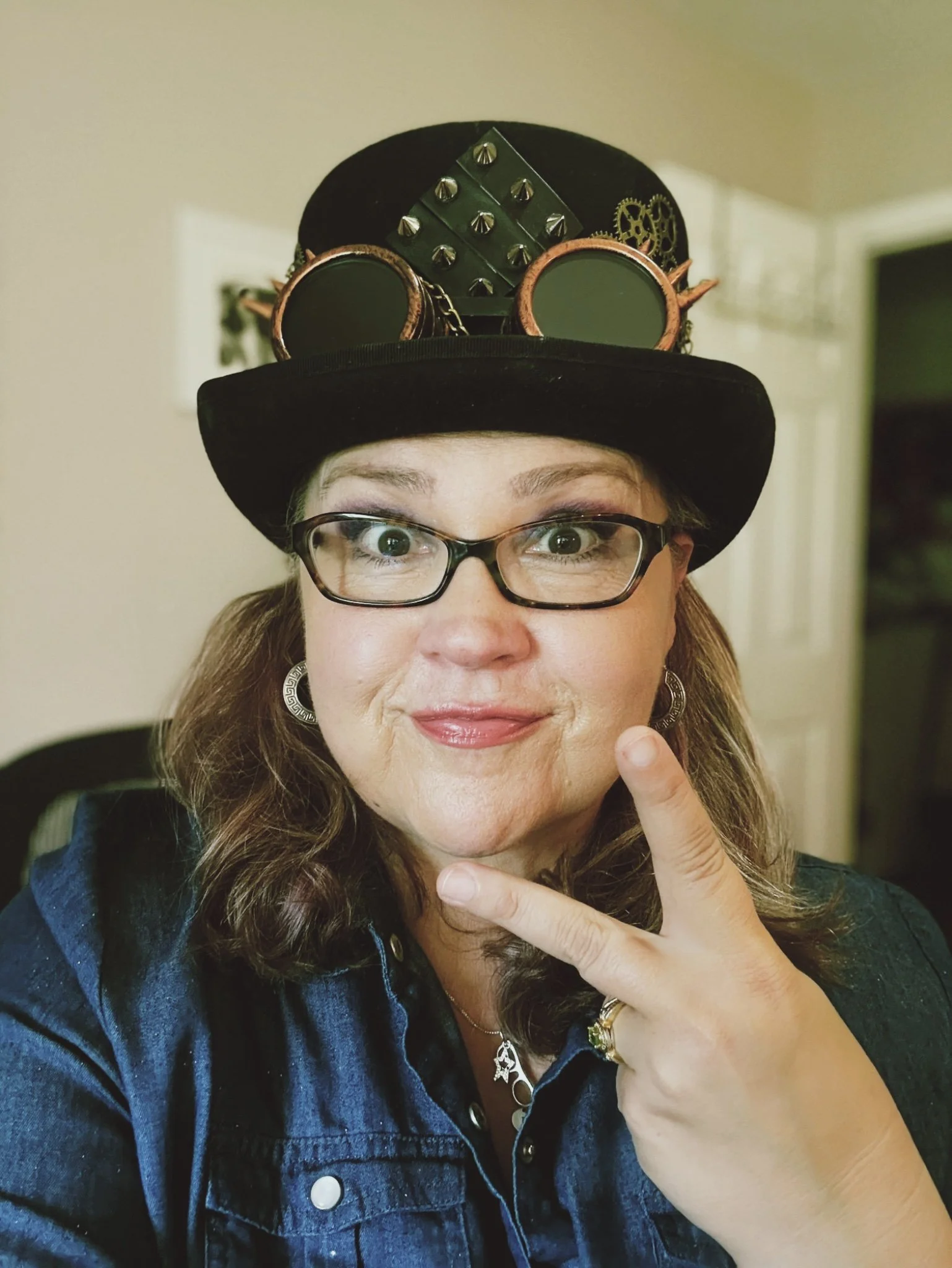 beth anne campbell giving peace sign wearing steampunk hat