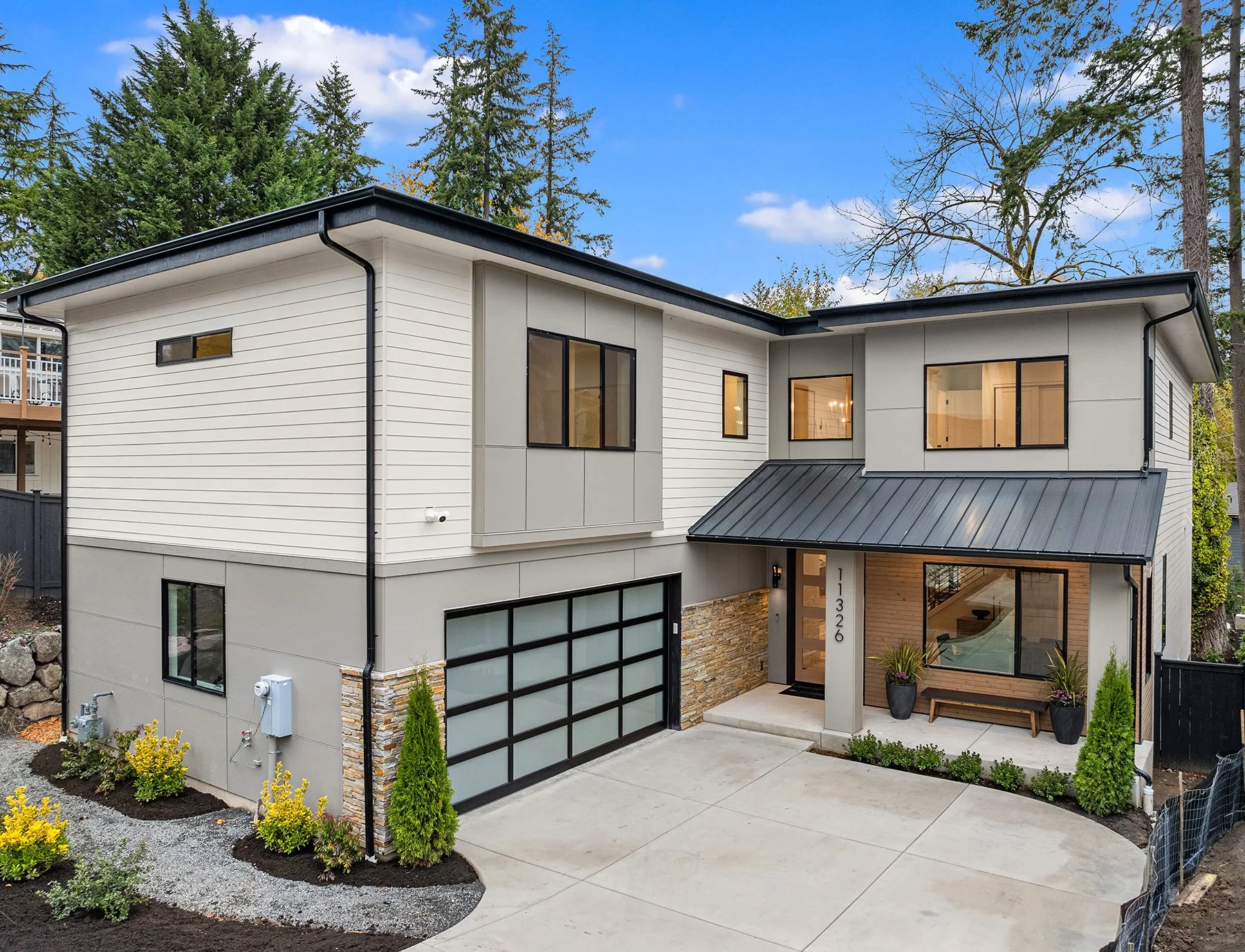 Street‑view of luxury modern home at the Bridges West in Kirkland WA with glass garage and covered entry.