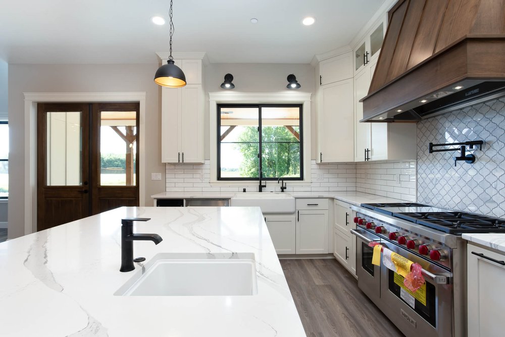 modern farmhouse kitchen with white countertops and chef's appliances