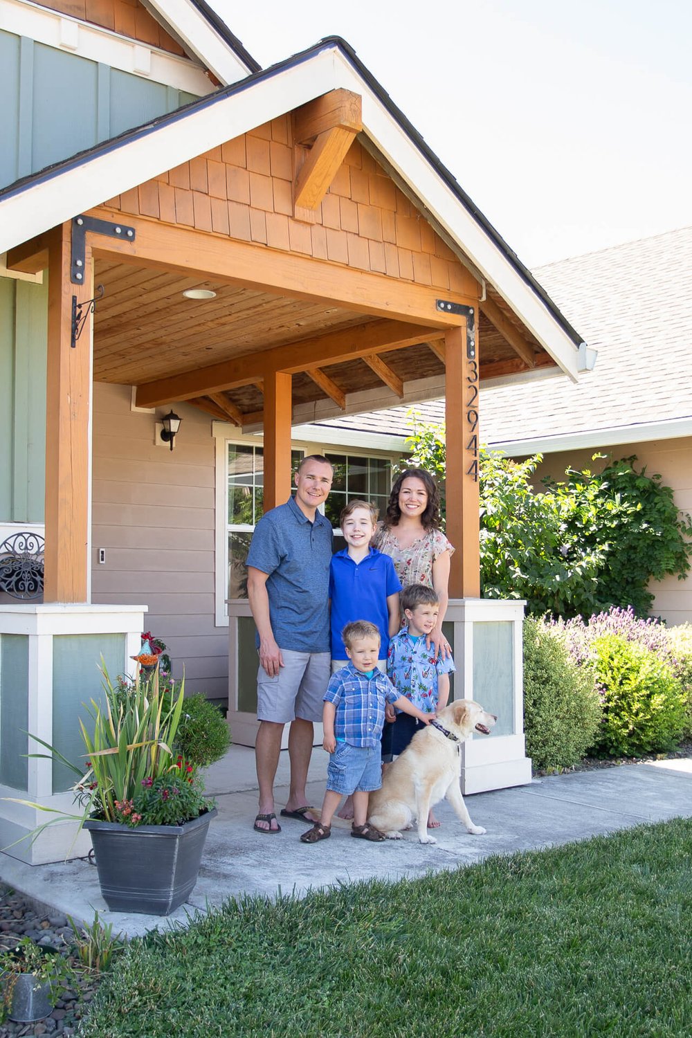 family and dog poses outside of Adair Home in Tangent, Oregon