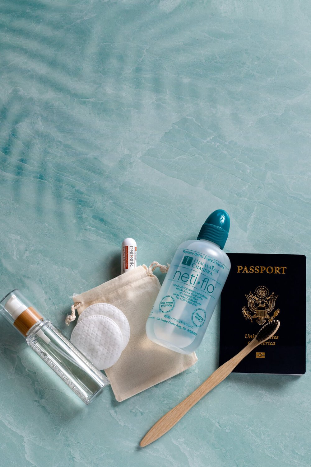 netiflo bottle with travel items and passport