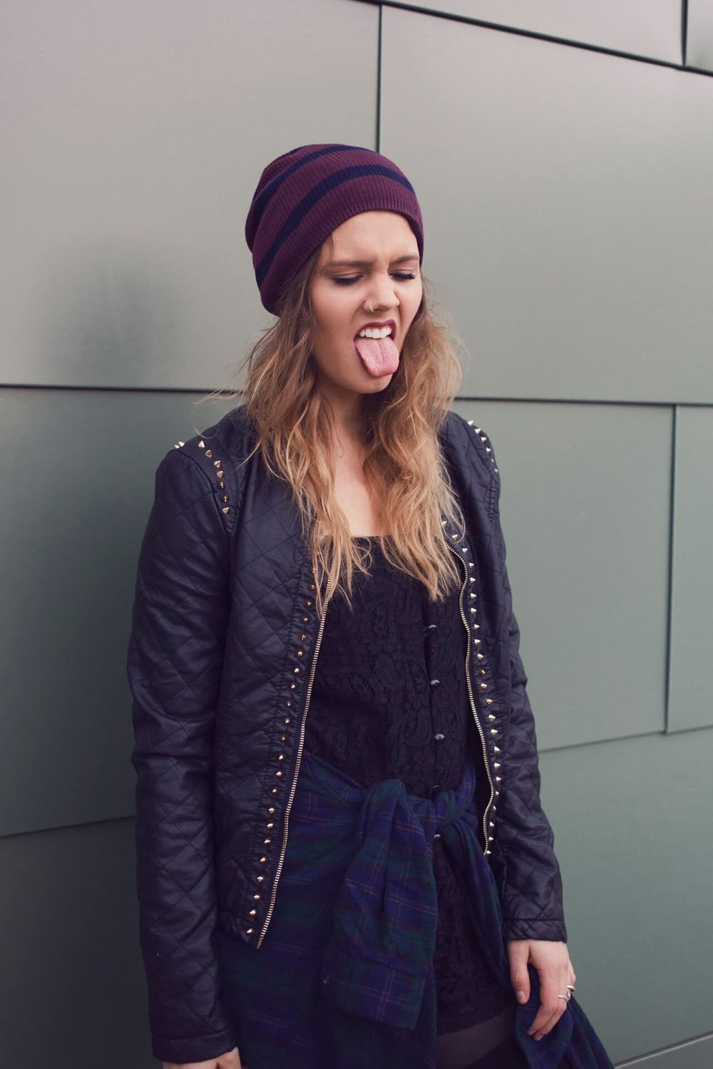 woman sticking out tongue in alternative outfit