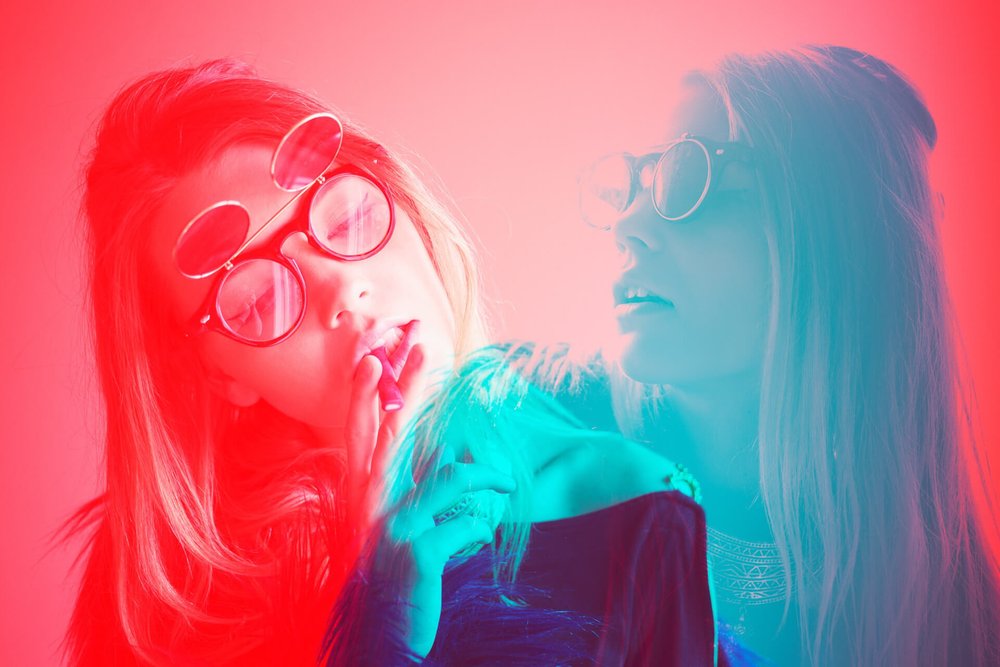 red and teal double exposure of blonde woman with glasses