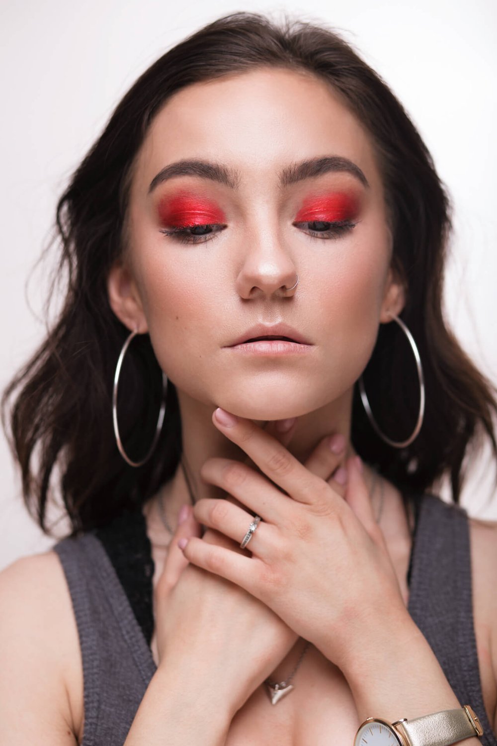 woman with red eyeshadow grabs her neck