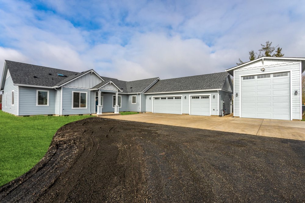 new build blue home with three car garage and separate rv garage in albany oregon