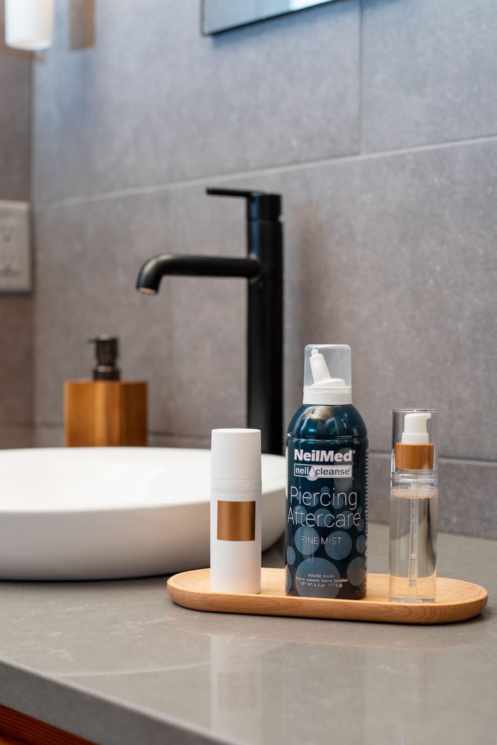 neilmed piercing and aftercare fine mist with other toiletries in modern bathroom