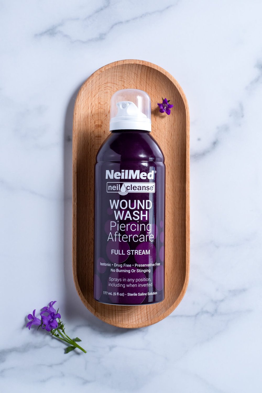 neilmed piercing and aftercare full stream on wood background with purple flowers