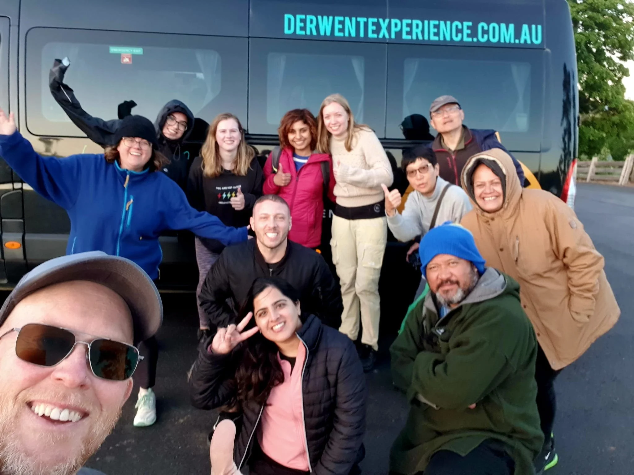 Happy group of travellers on the Cradle Mountain day tour with Sam and The Derwent Experience, on the return leg to Hobart after great day in the National Park, hiking and filling up on Nature