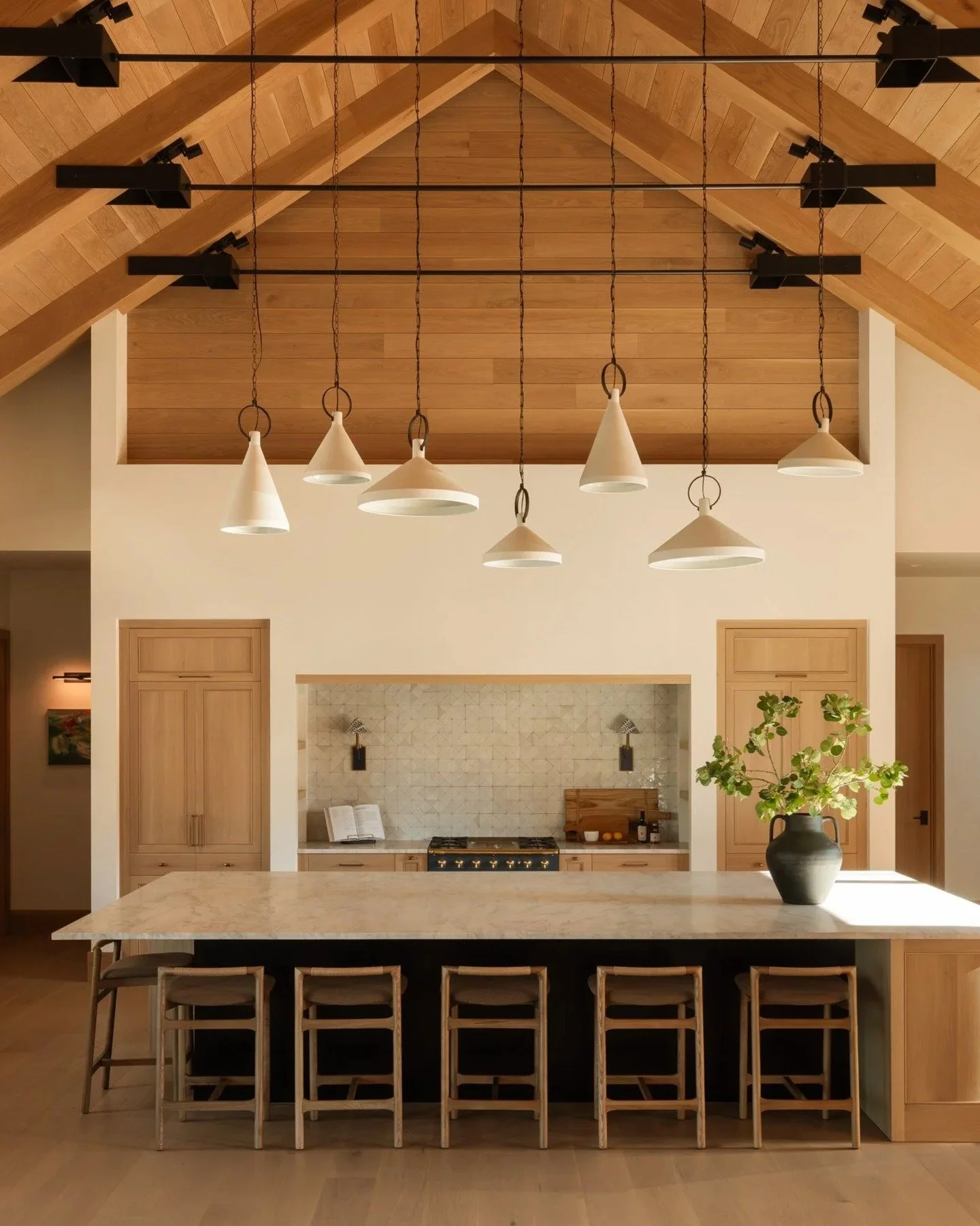 Heartwood is the dense core of a tree, the oldest and most durable wood it has. It felt like the right name for this one.

Timber trusses span the great room. White oak starts at the oversized pivot door and carries through the cabinetry and built-in