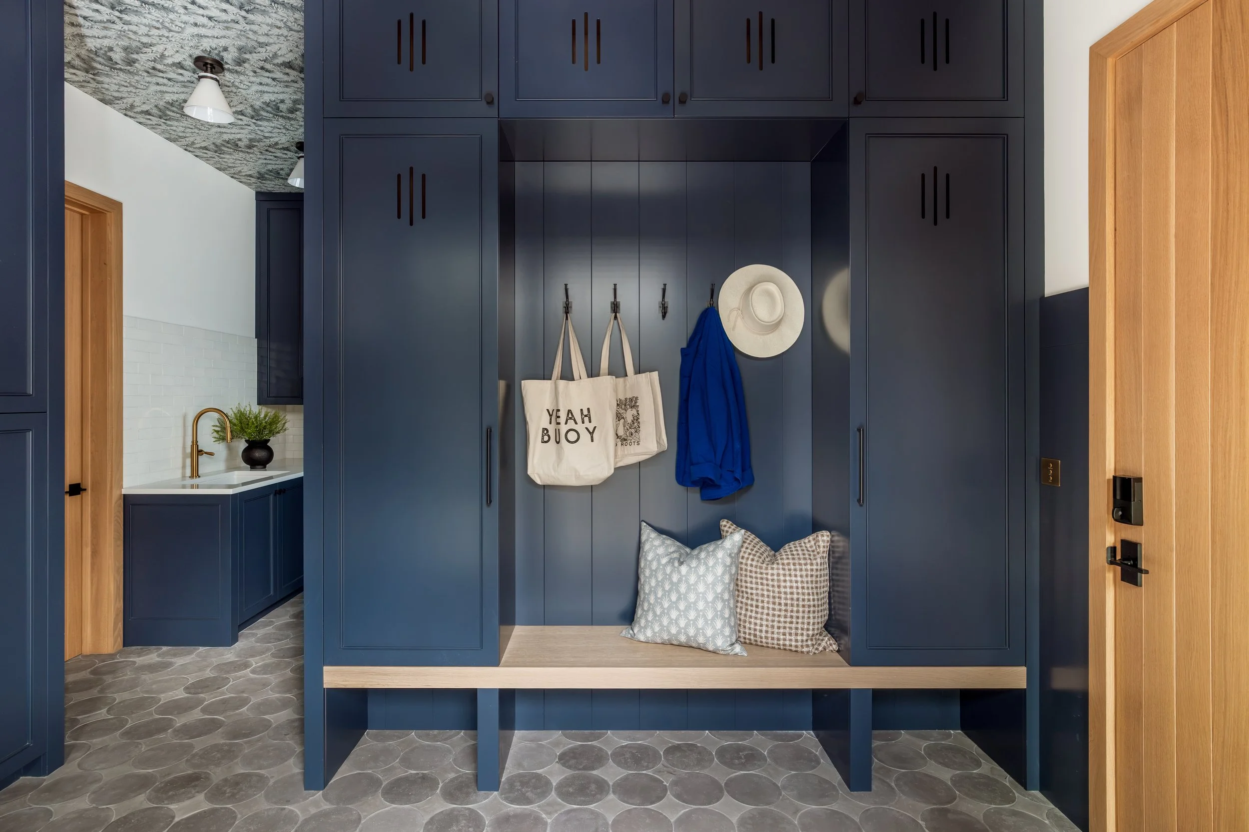Mudroom with custom navy lockers and a built-in bench.