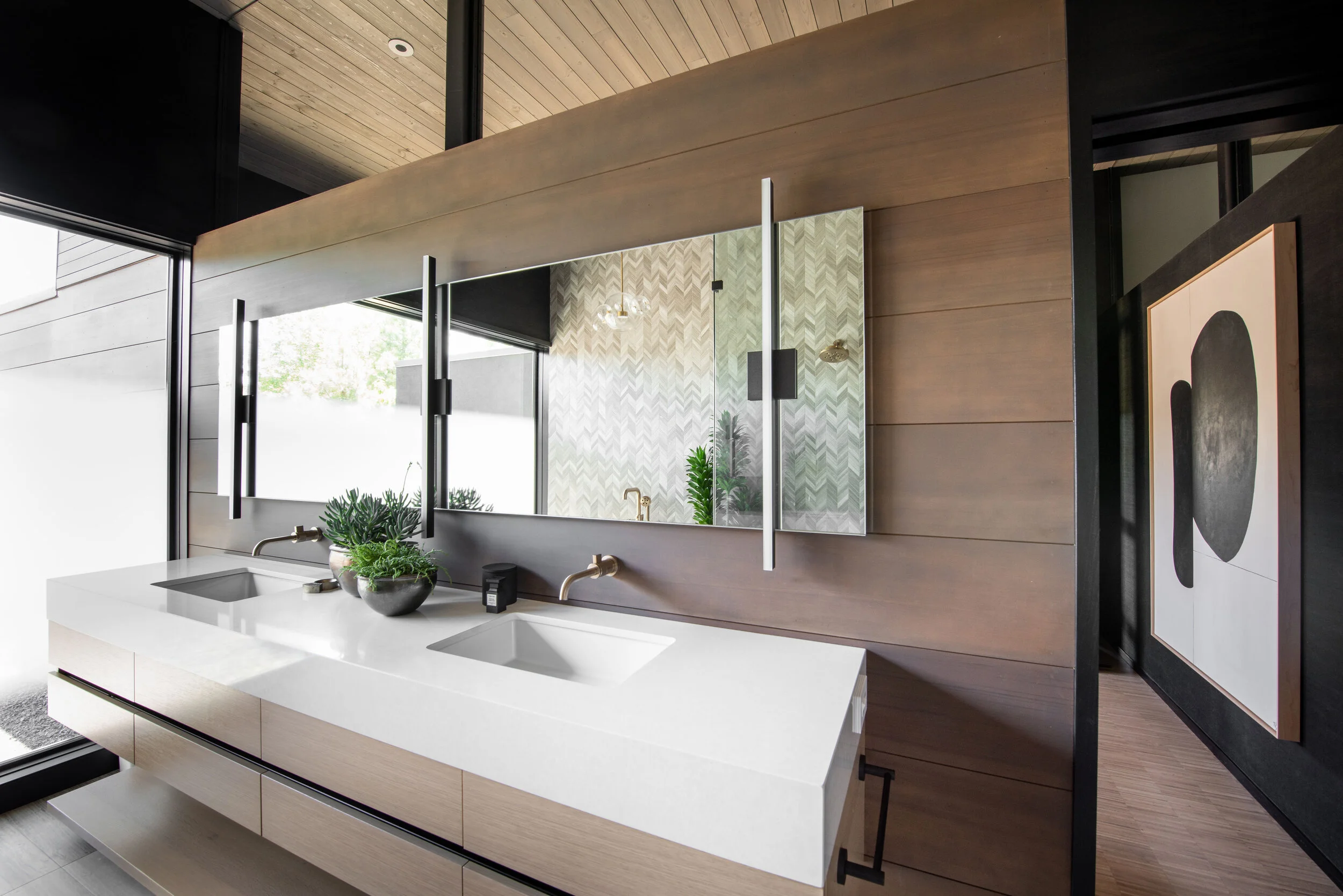 Custom primary bathroom with floating double vanity, brass fixtures, and chevron tile shower — selections come together in a Bend, Oregon home built by Copperline Homes.