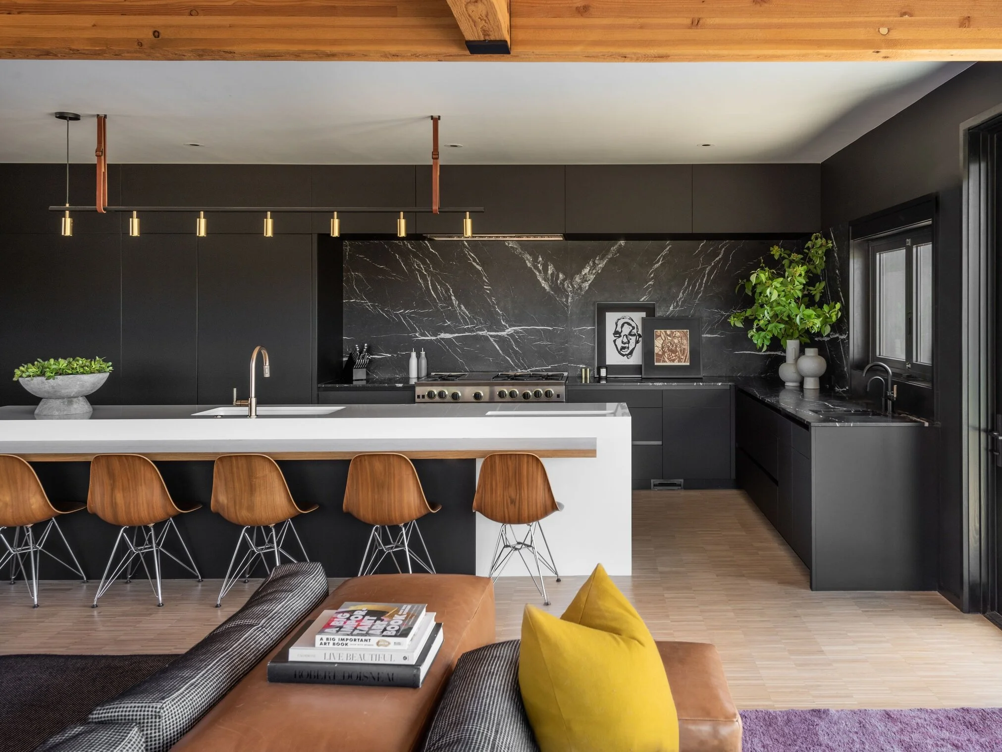 "Modern kitchen with black cabinetry marble backsplash and waterfall island in Bend Oregon custom home