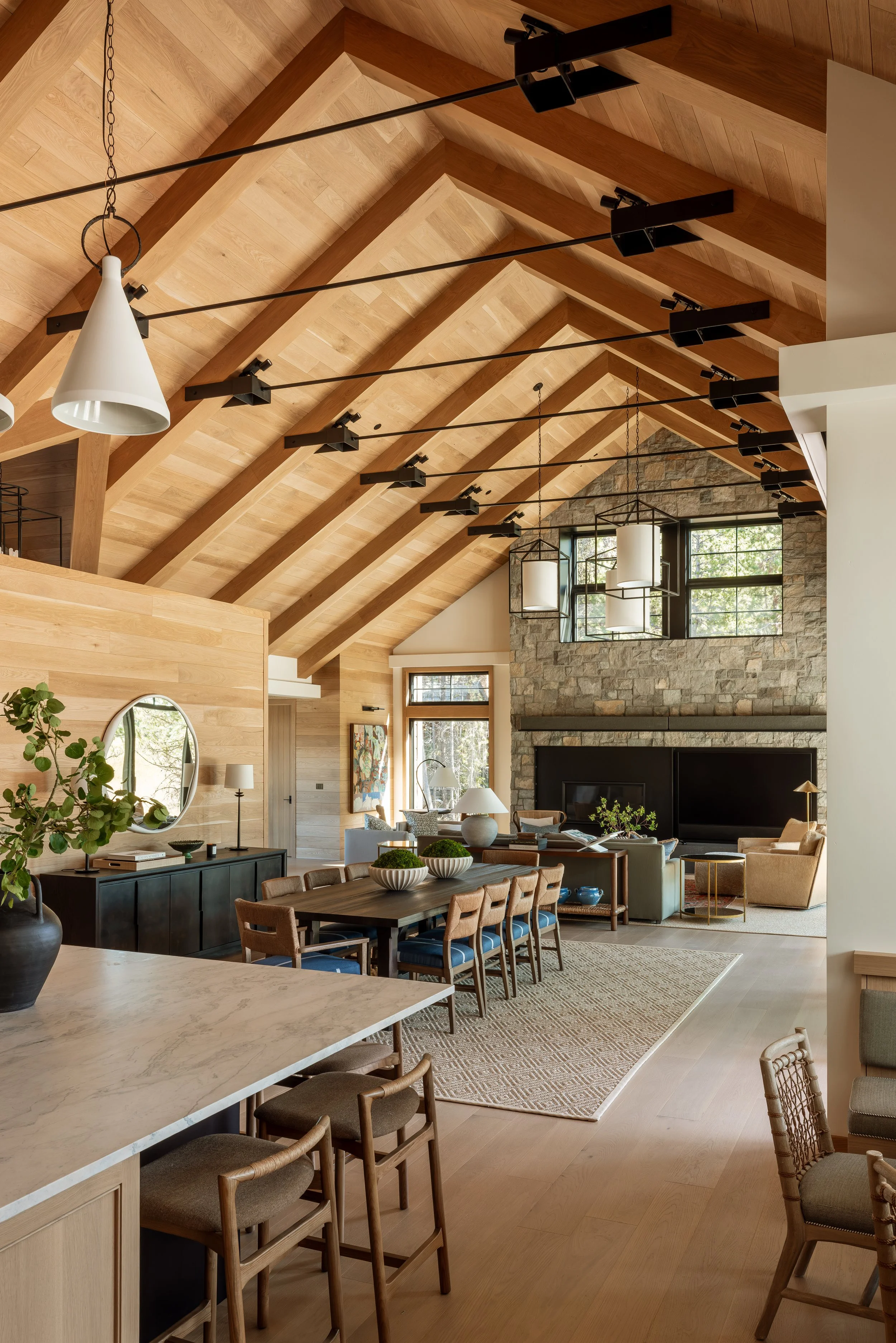 Great room with exposed timber trusses spanning the kitchen, dining and living areas.