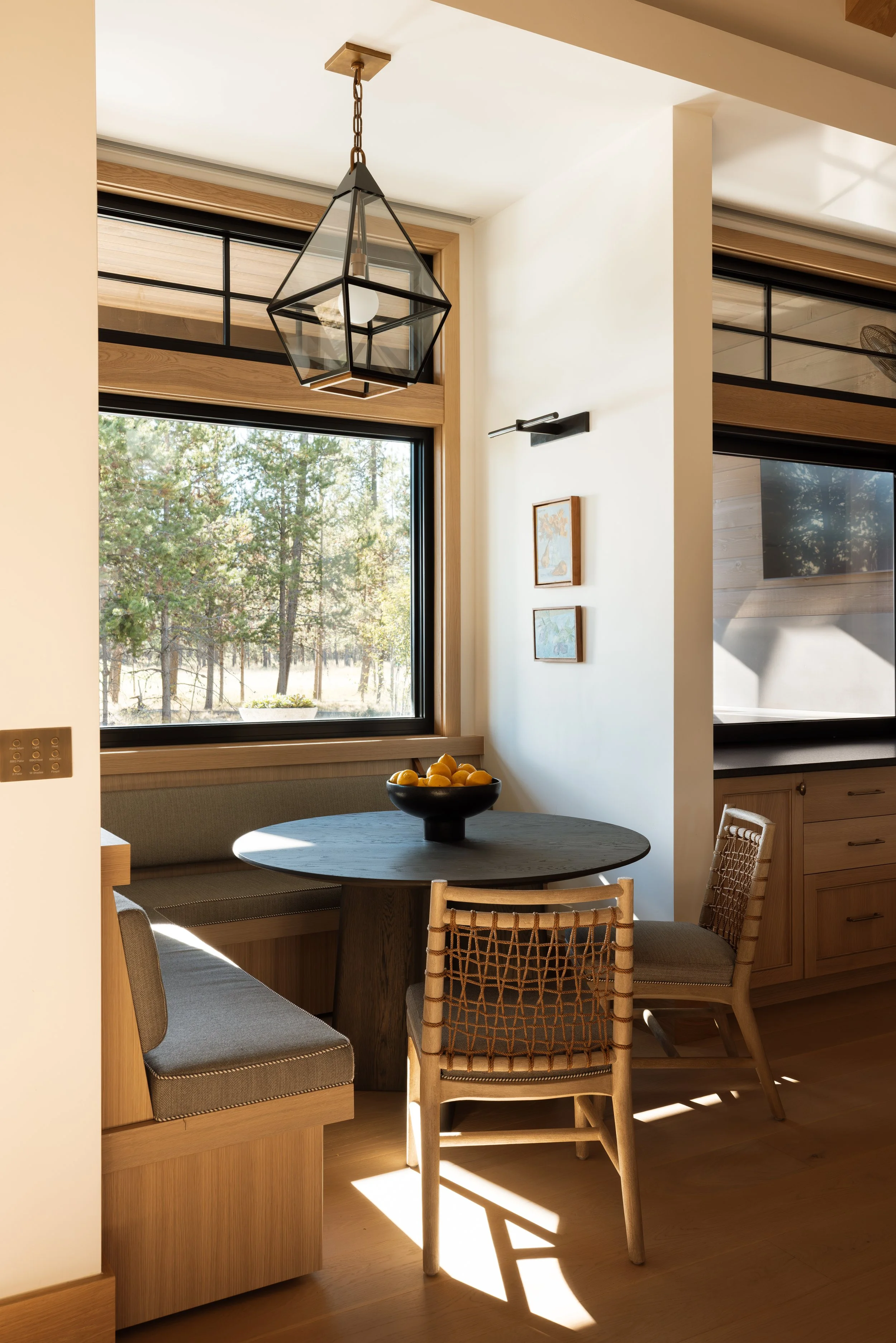 Breakfast nook with a built-in banquette and views into the pines.