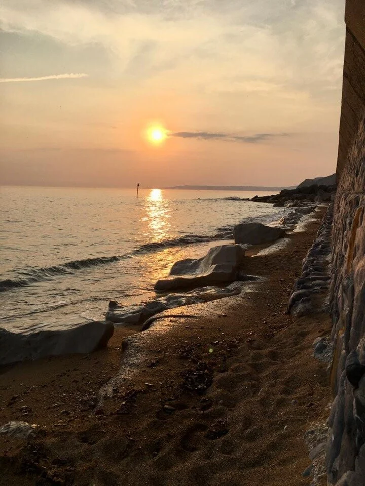 Sun setting over the ocean in Dorset, England