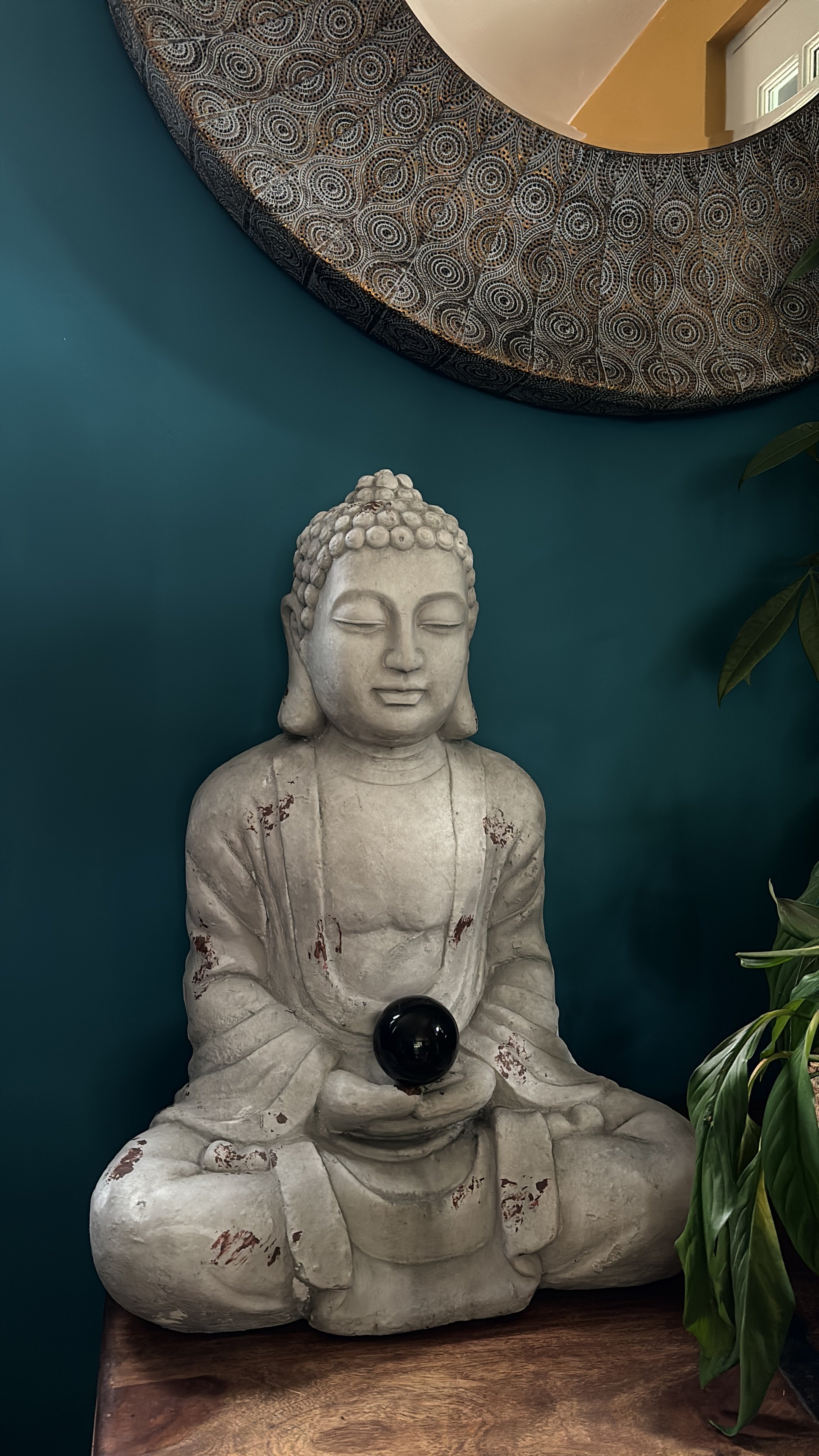 A calming Buddha in the seated meditation (Dhyana) position with a crystal orb.
