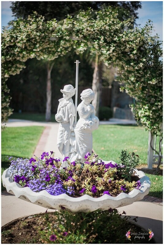  statue with purple flowers at wedding garden 