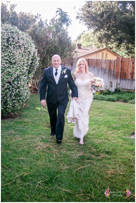  bridge and groom walking through the grass of the garden 