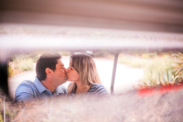 newly engaged couple kissing on a golf cart 