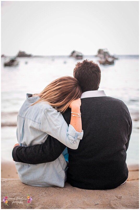  woman leans her head on her partners shoulder looking at the water 