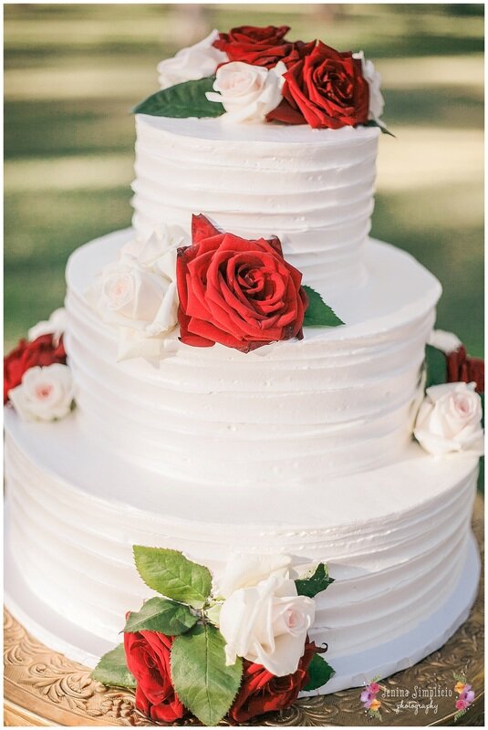 White wedding cake with red and white roses