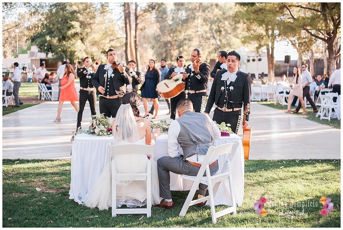  Bride and groom sitting and watching the mariachi band 