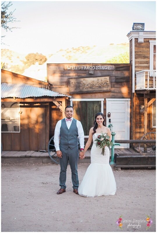  Bride and groom holding hands in front of the ranch 
