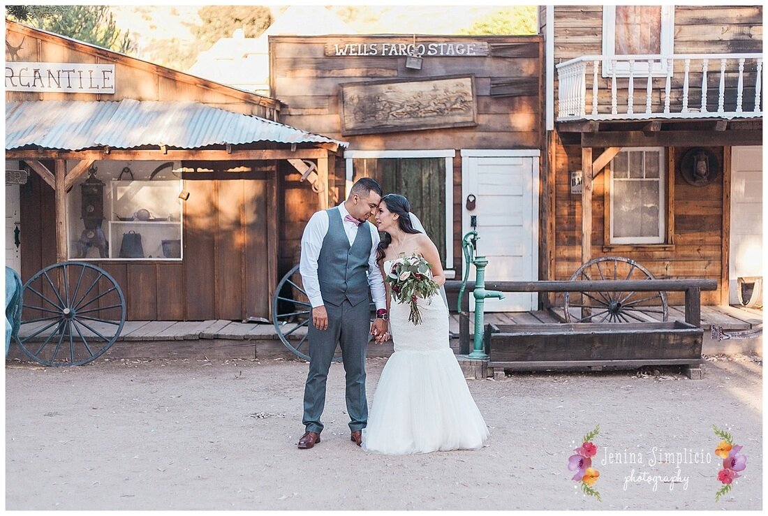  Newlyweds in front of the ranch holding hands 