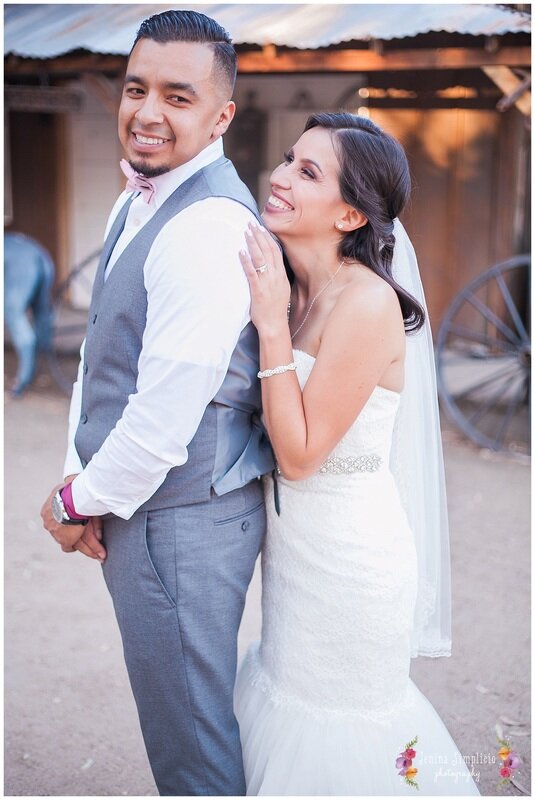  bride smiling behind the groom with her hands on his shoulders 