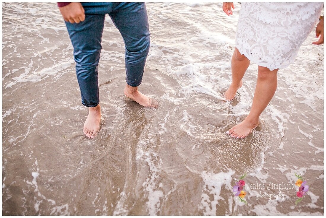  newly engaged couple wading in the ocean at the beach 