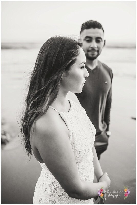  black and white photo of a newly engaged couple on the beach at sunset 