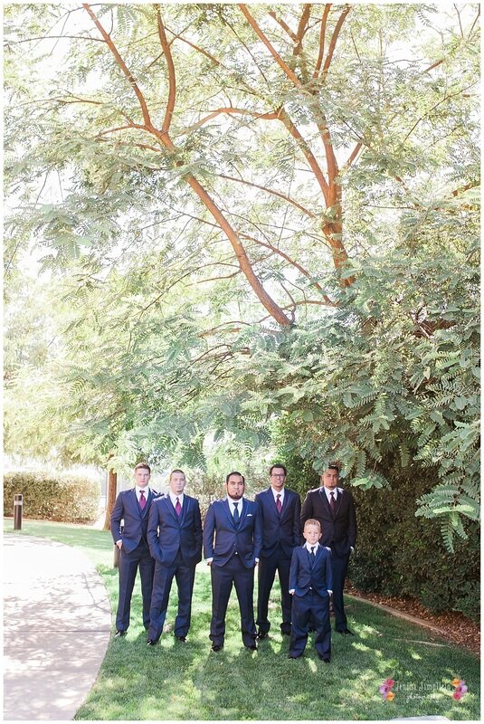  wide shot of the groomsmen out in the garden path 